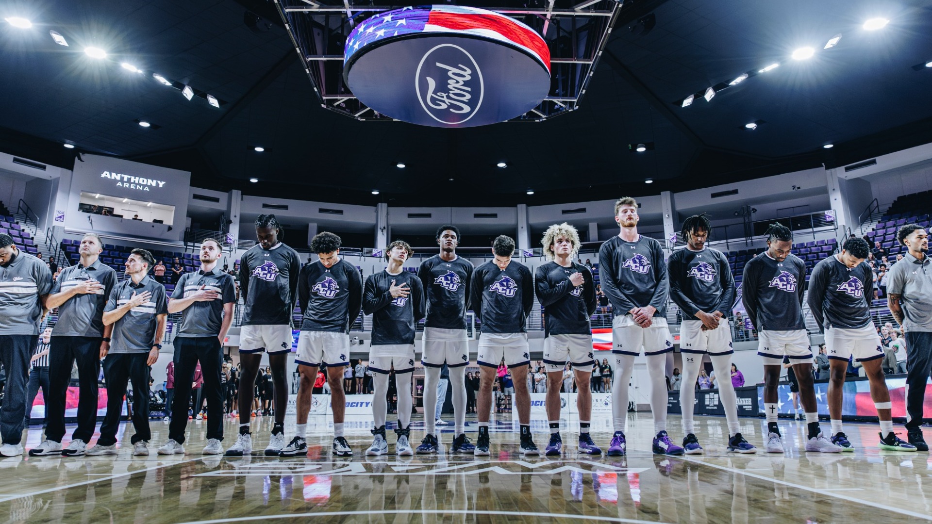 ACU men's basketball team stands for the national anthem before the opening game of the 2025-26 season