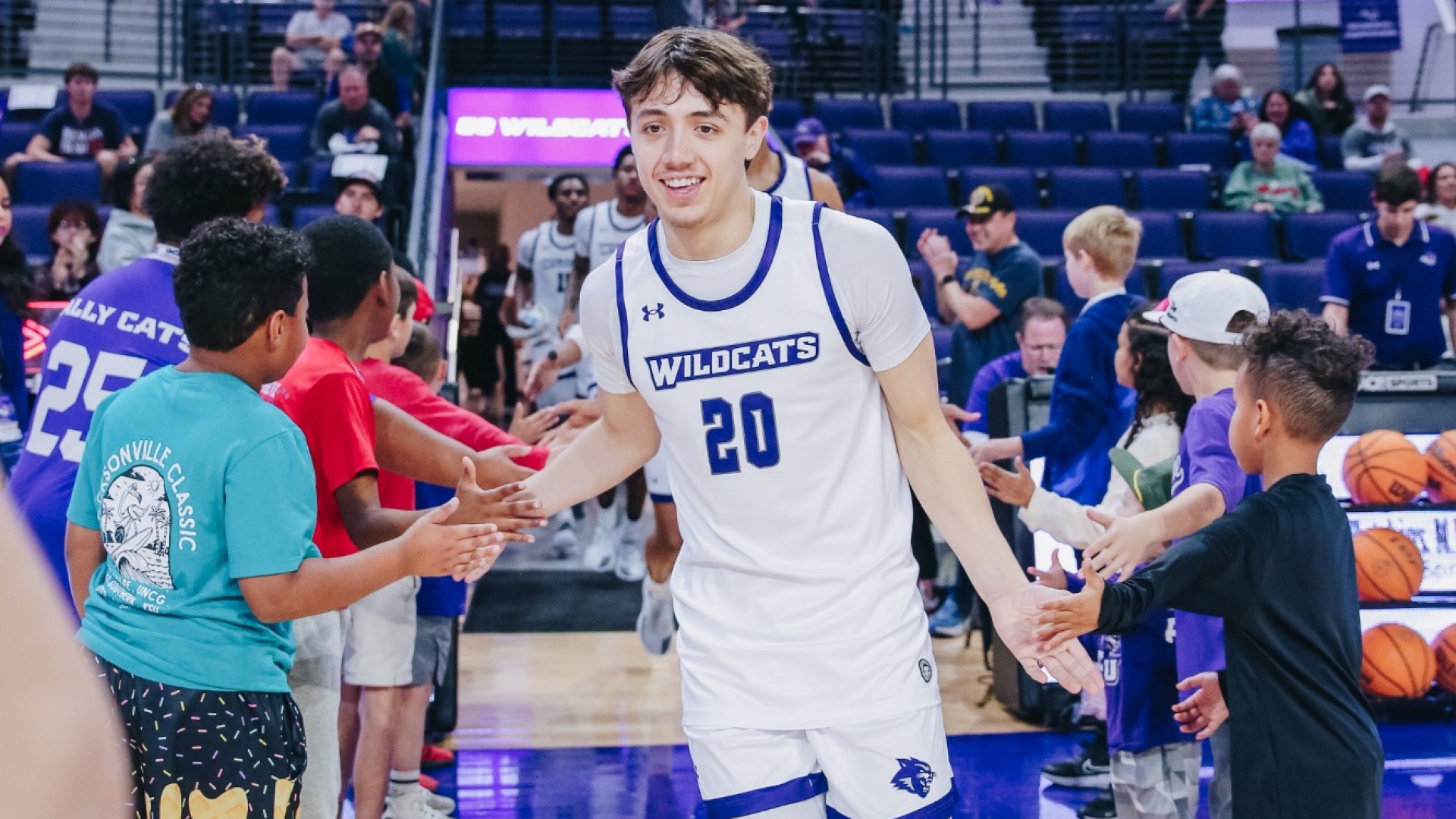 Isaiah Carrillo runs through a high-five line of kids onto the court for warmups before playing New Mexico State on Dec. 6, 2025