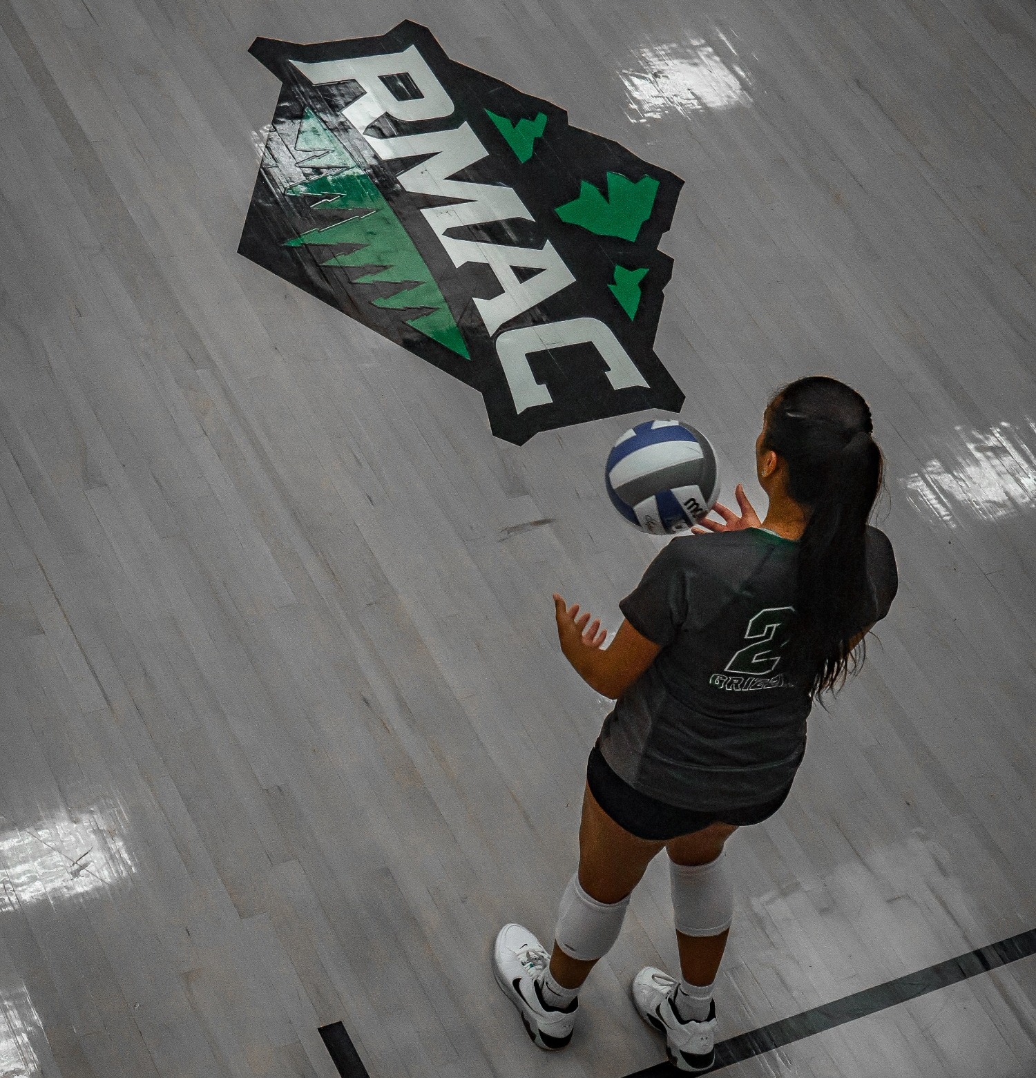 RMAC Logo with Adams State Volleyball Player getting ready to serve