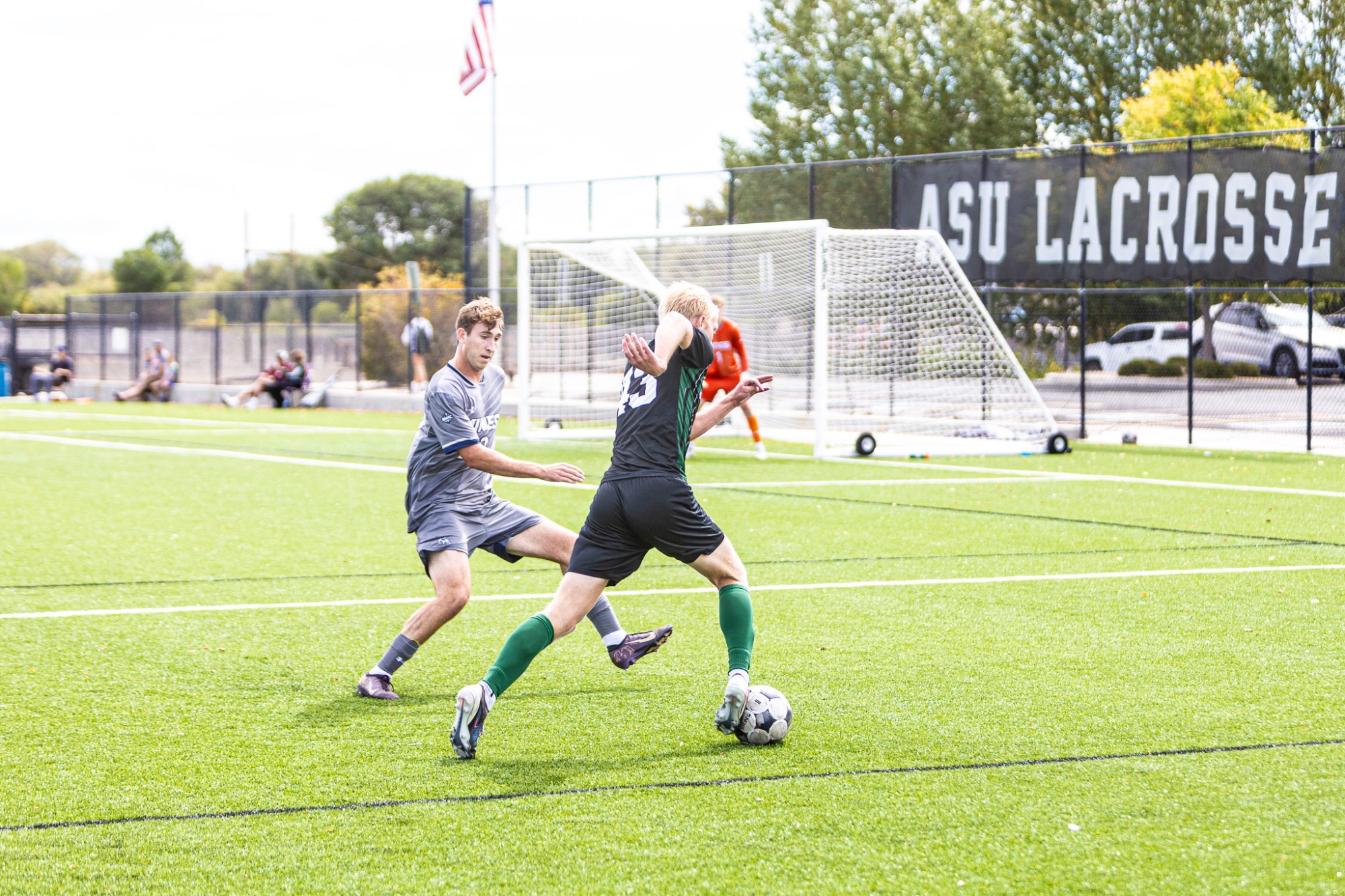 Adams State soccer player #43 Kadin Reese kicks ball and runs pass Mines defender in their matchup on September 16, 2026