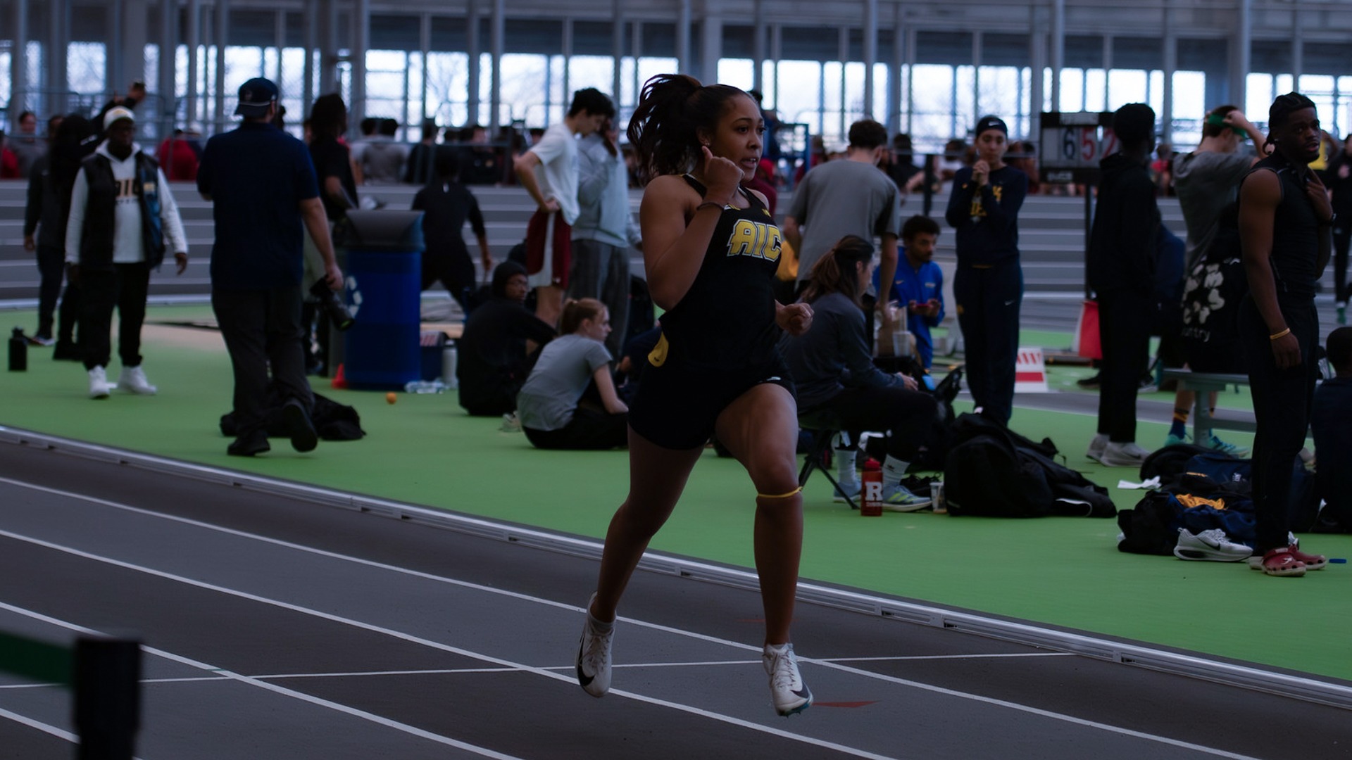 An AIC track runner gives a thumbs up during her race at the 2025 Seahawk Shootout