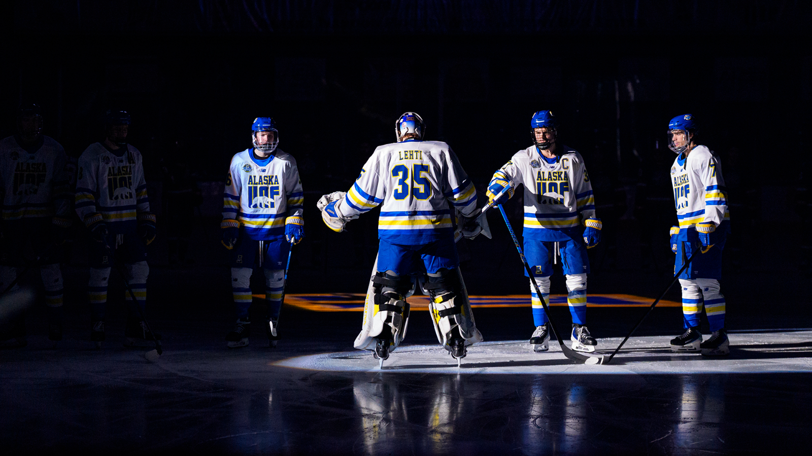 Lassi Lehti high fives teammates on the blue line during starting announcements