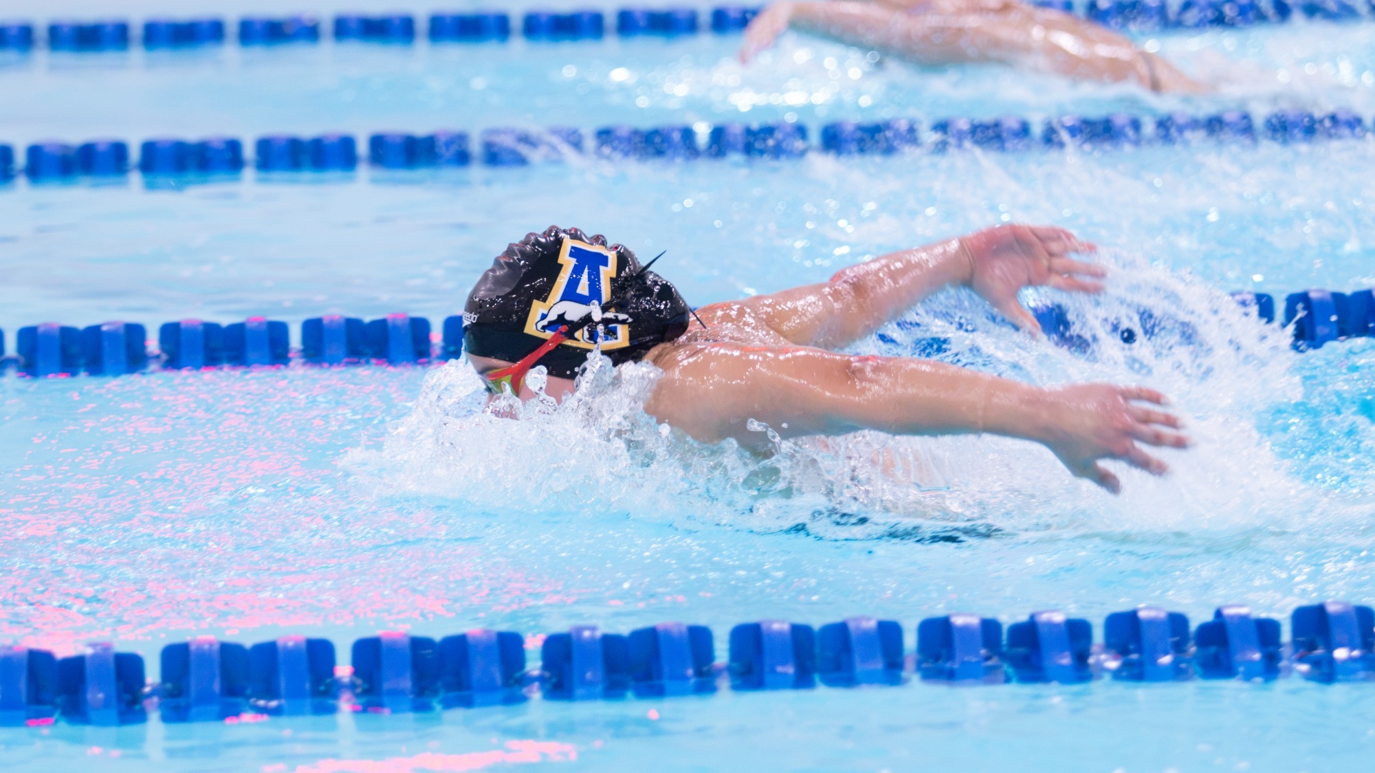 A Nanooks swimmer in the butterfly in a dual meet against Azusa Pacific