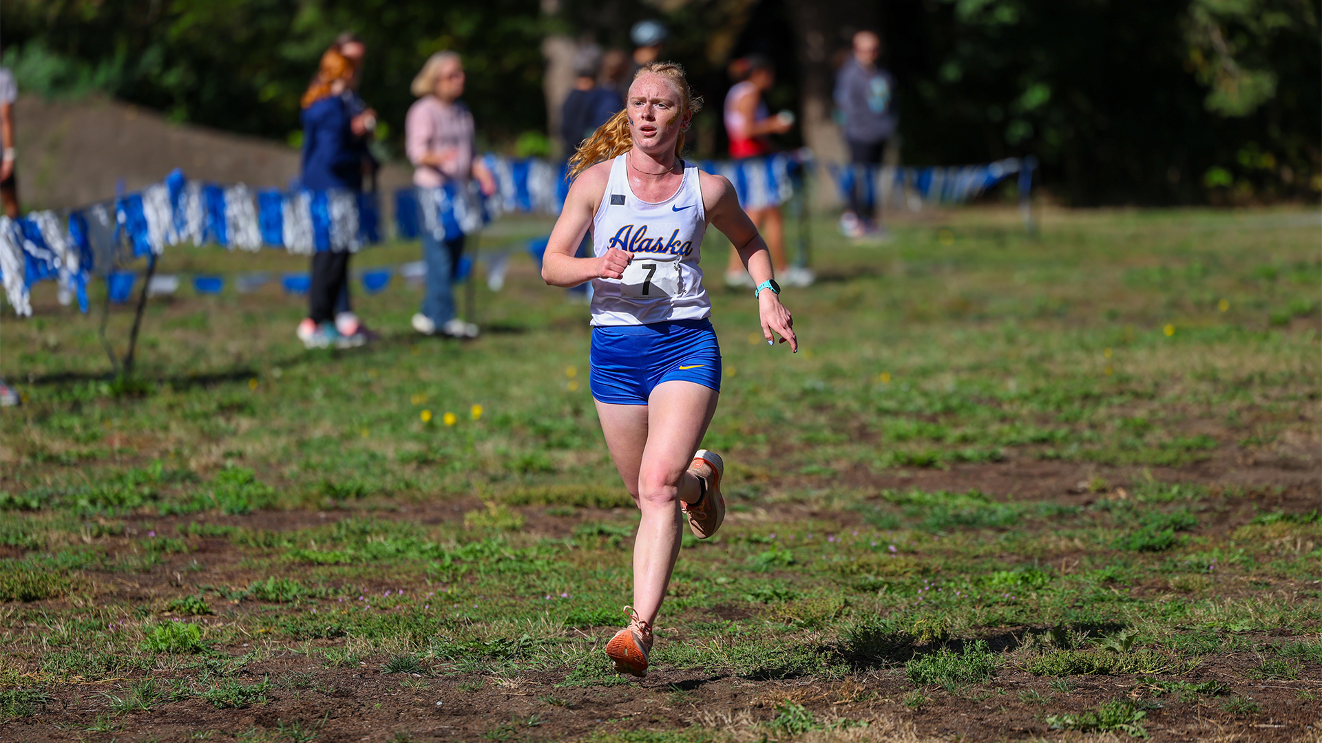 Emma Niedbalski running through finish line at Bill Roe Classic