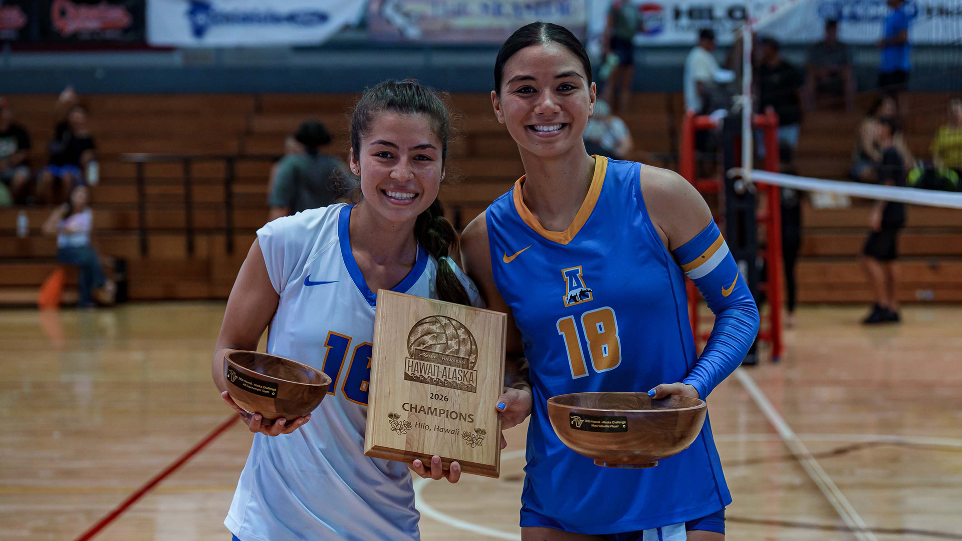 Tessa Onaga (L) and Haylee Lyons (R) pose with the championship trophy and their All-Tournament trophies