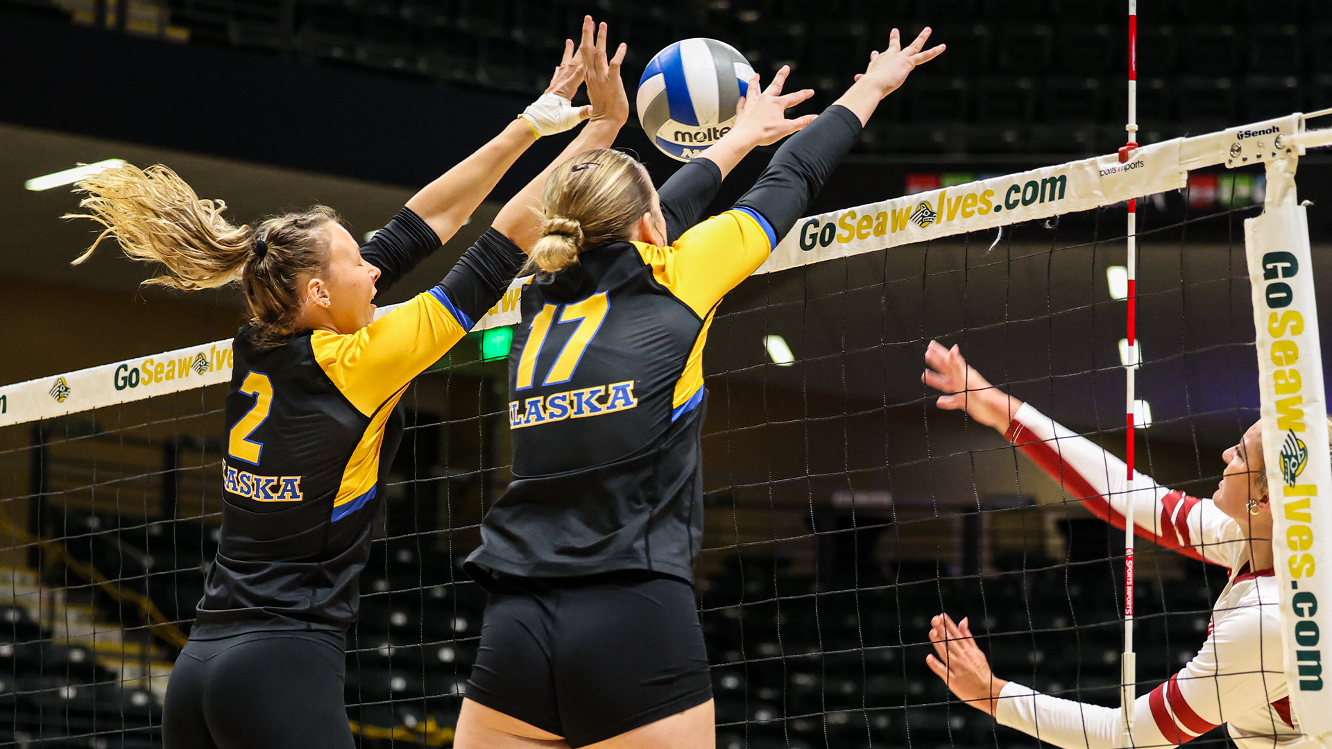 Presley Engelauf (L) and Cori Leavitt (R) team up for a block in Anchorage against TWU