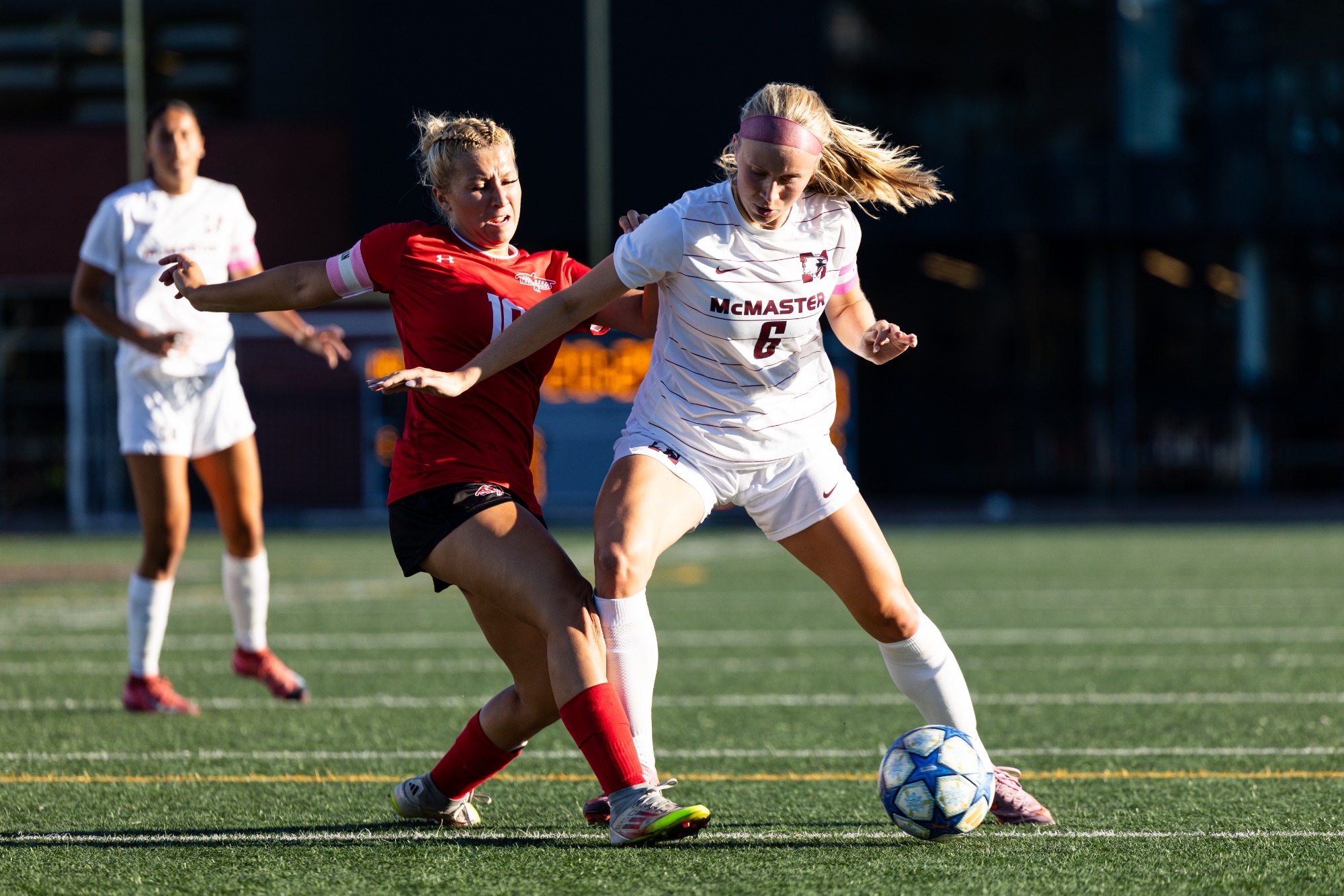 #10 Samantha Mazzuca of the Algoma Thunderbirds battles a McMaster Marauders attacker