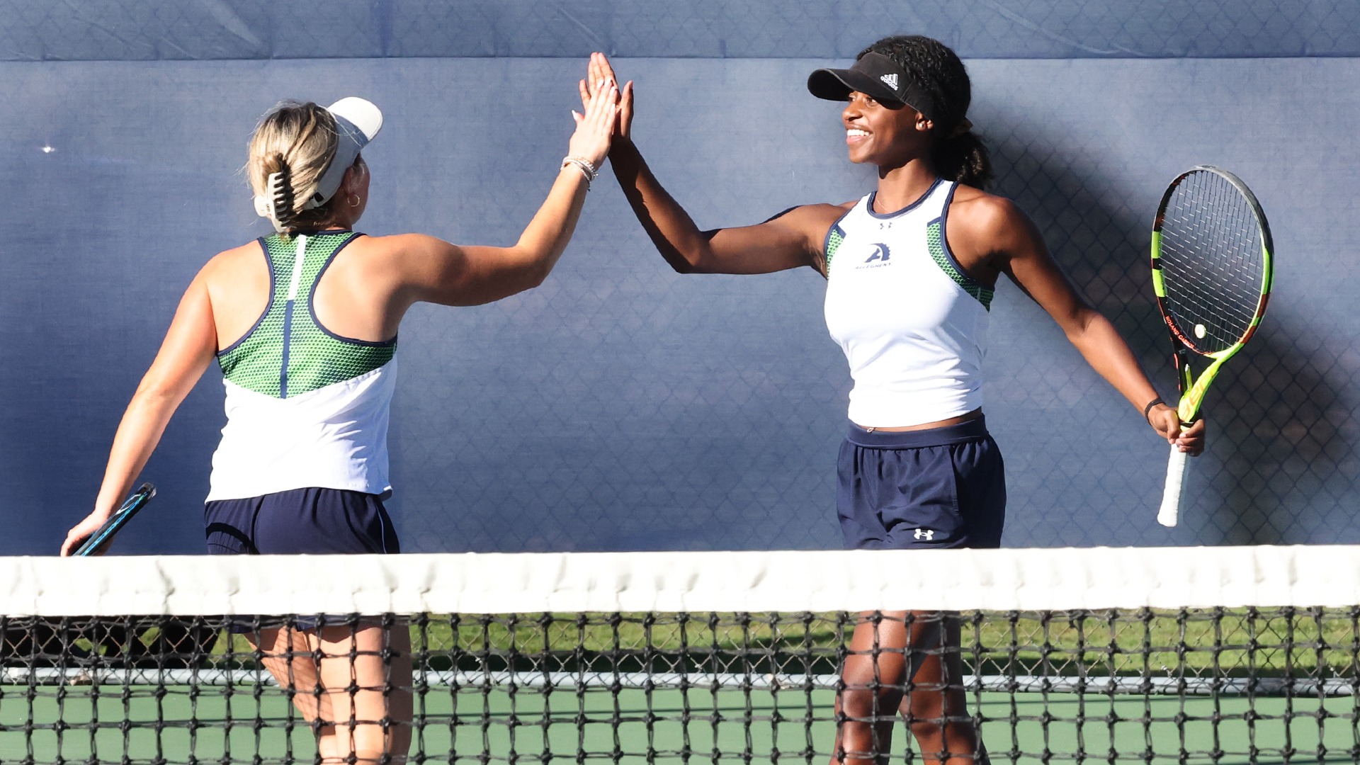 Maria Lounder (L) and Gabrielle Bassette (R) high five in their doubles match vs. W&J, Oct. 16, 2025. Photo by Ed Mailliard.