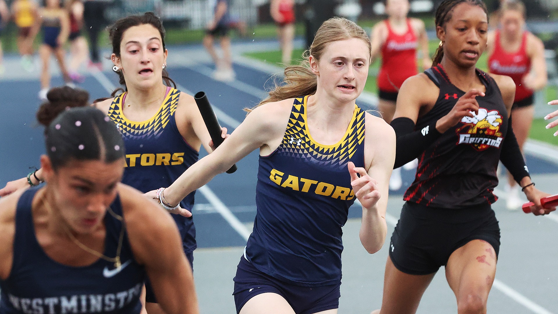 Renee Tetlow takes the baton in record-setting 4x100 relay at Marty Goldberg Gator Invitational, April 24, 2026. Photo by Ed Mailliard.