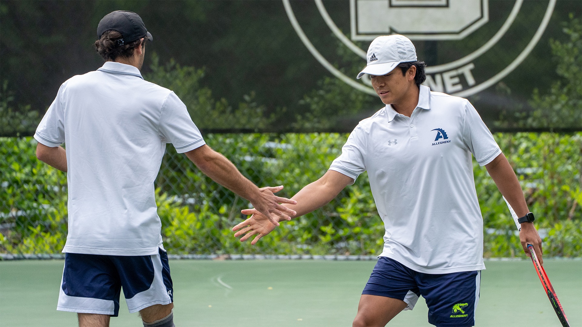 Zidaan Hassan (L) and Adam Memije (R) high-five in doubles match vs. Swarthmore, May 9, 2026. Photo by Matt Mizanin/Swarthmore Athletics.