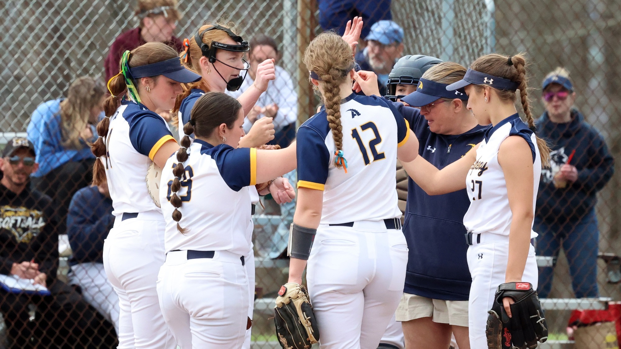 Softball team huddle vs. Thiel, April 12, 2026. Photo by Ed Mailliard.
