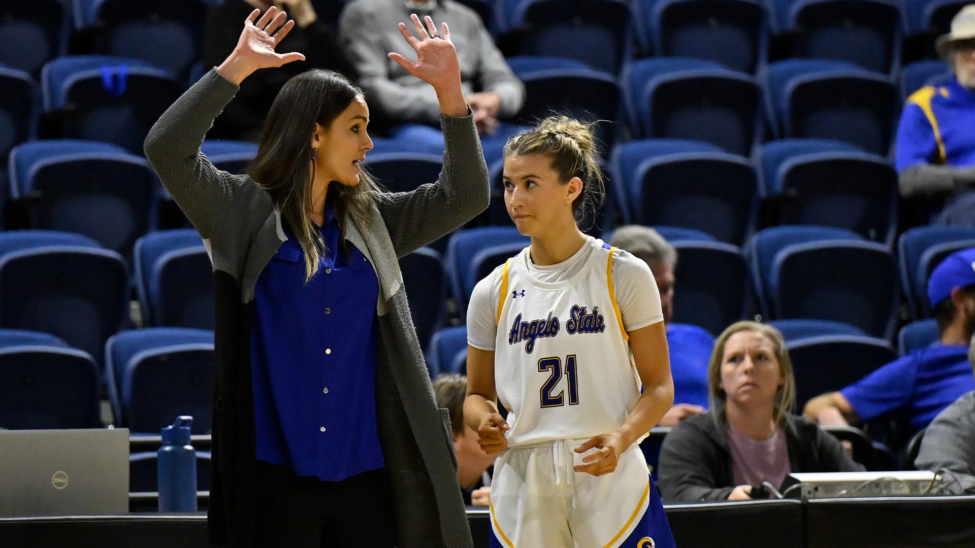 Coach Ellis raising her hands in the air to coach Majik Esquivel