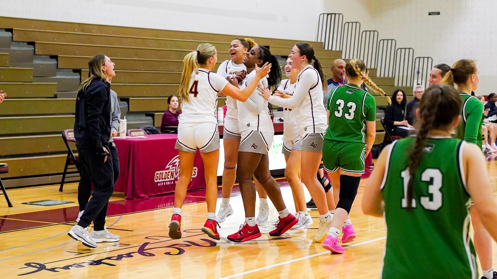 Alvernia Celebrates with Taryn Woodson following the scoring of her 1,000th point