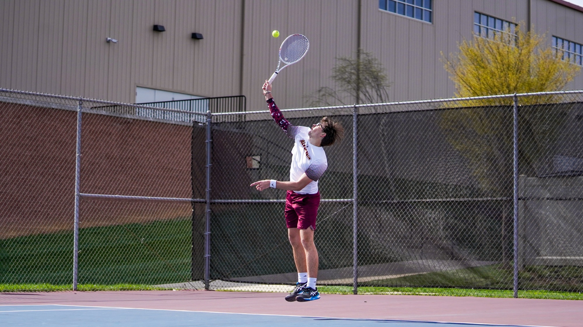 Luke Brisbois serves the ball in a match against his opponent.
