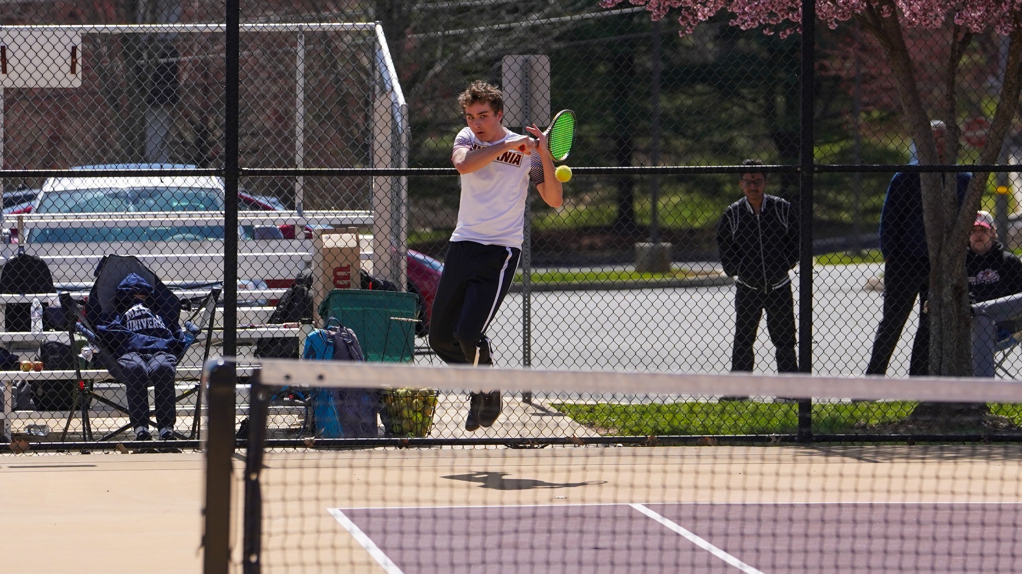 Lucas Montello returns a shot in men's tennis action