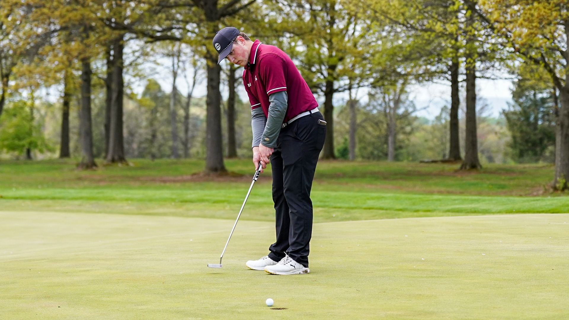 Zachary Neuin rolls in a putt at the MAC Championships
