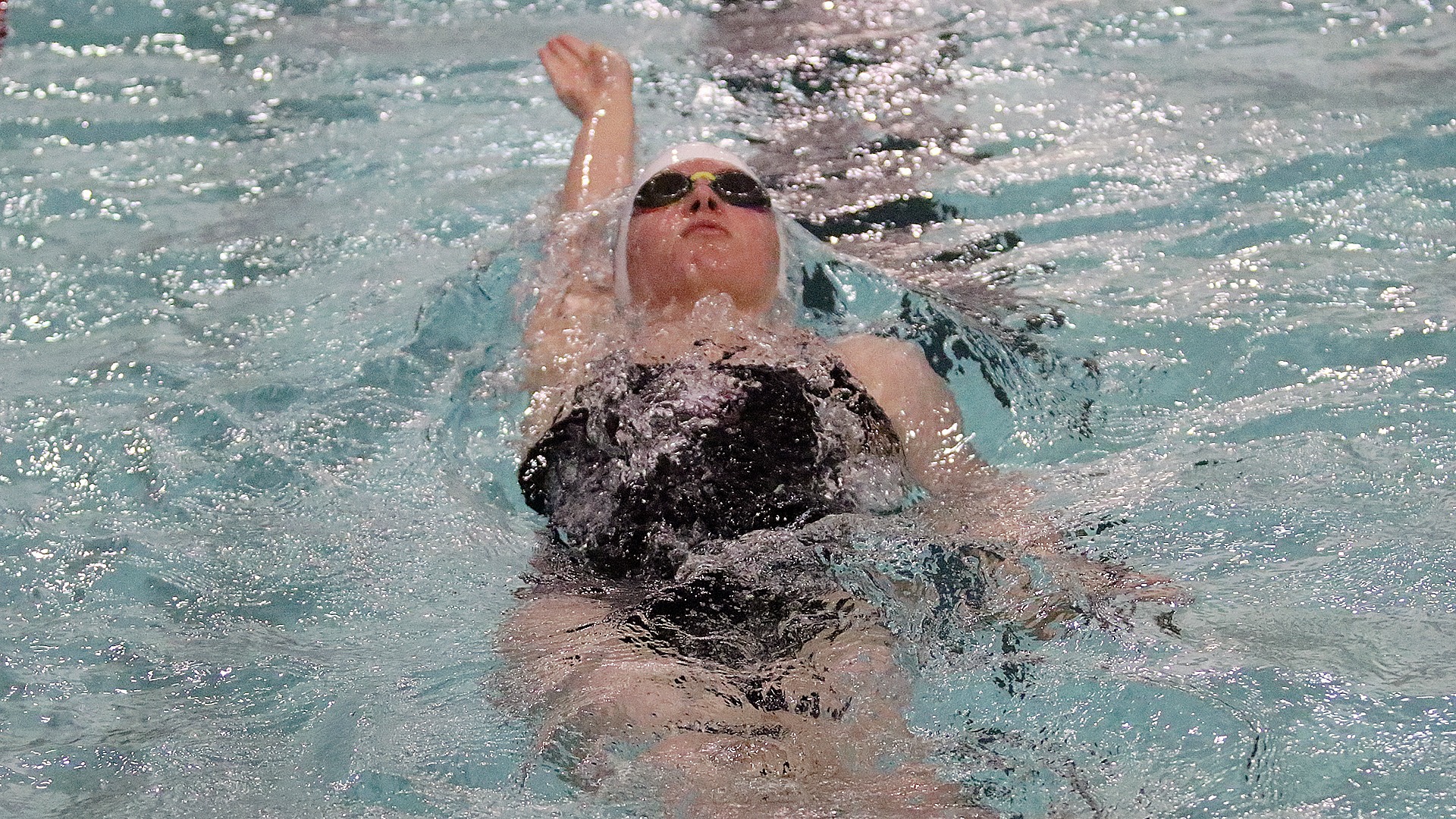 Kaia Anderson competes in the backstroke during a 2025-26 Augsburg women's swimming and diving meet.