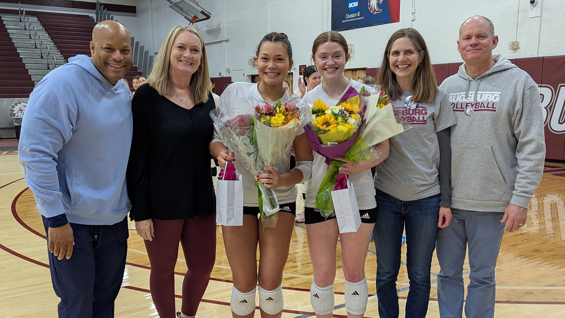 Augsburg volleyball seniors and their families pose for a photo.