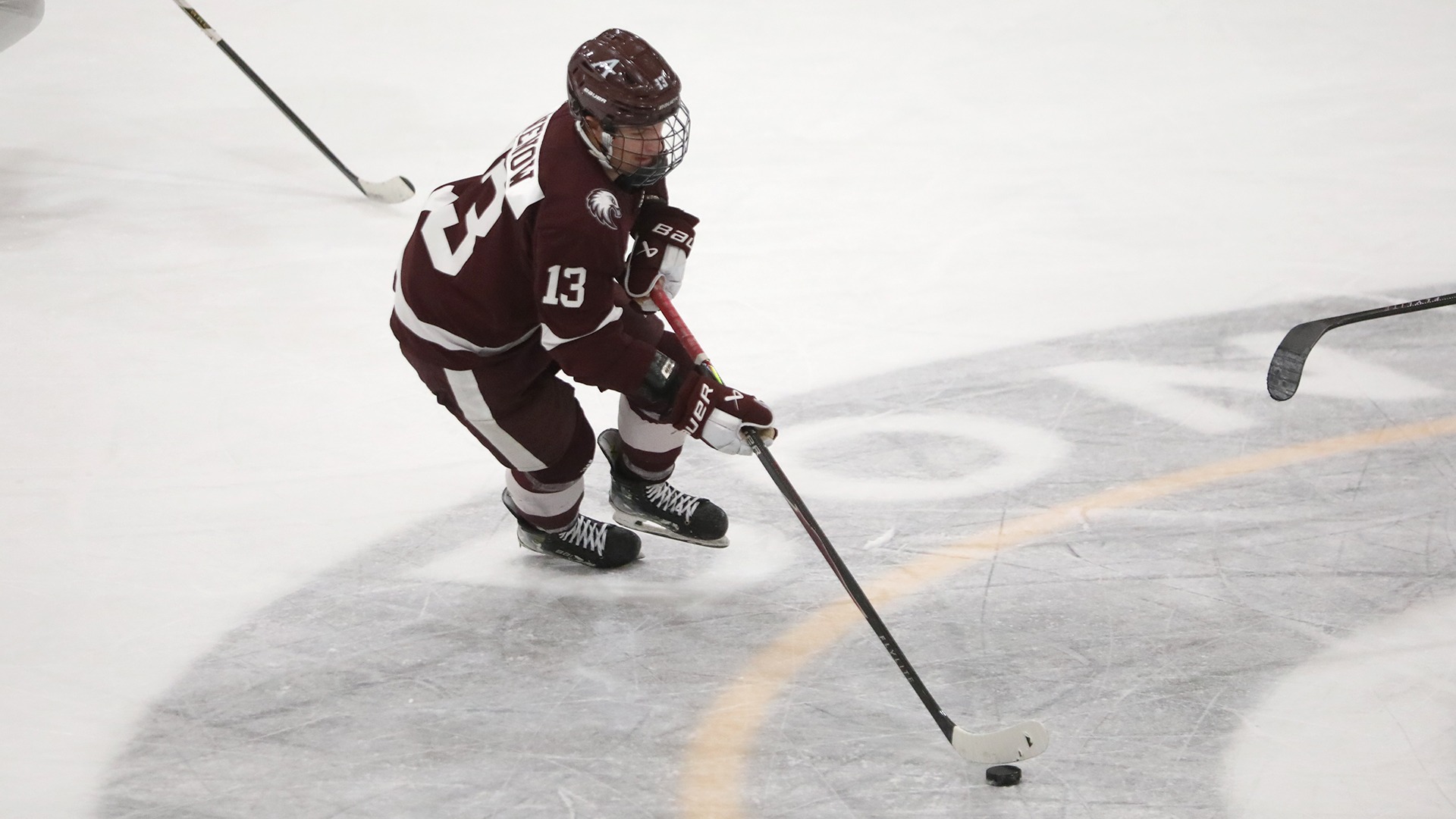 Nolan Nenow works the puck up the ice during a 2025-26 Augsburg men's hockey game.