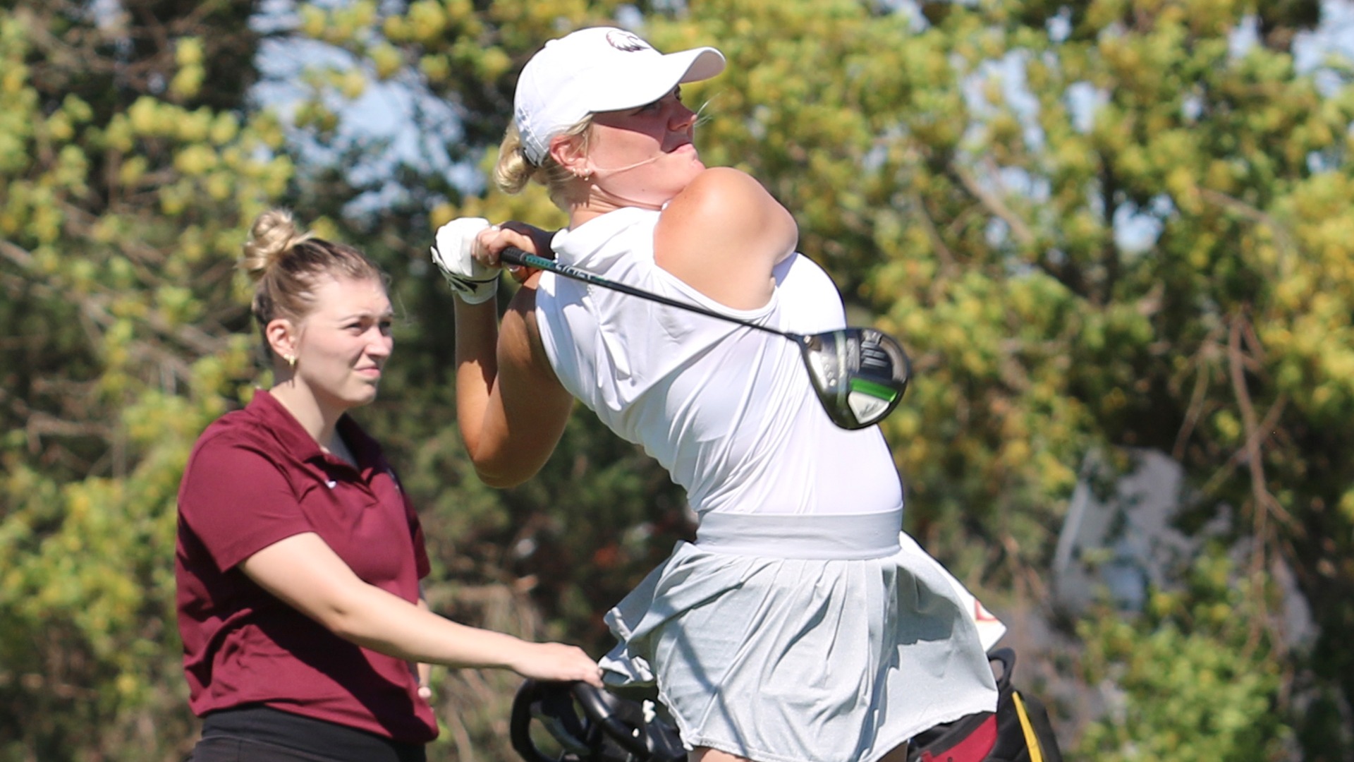 Emma Larsen follows through on a tee shot during a 2024-25 Augsburg women's golf meet.