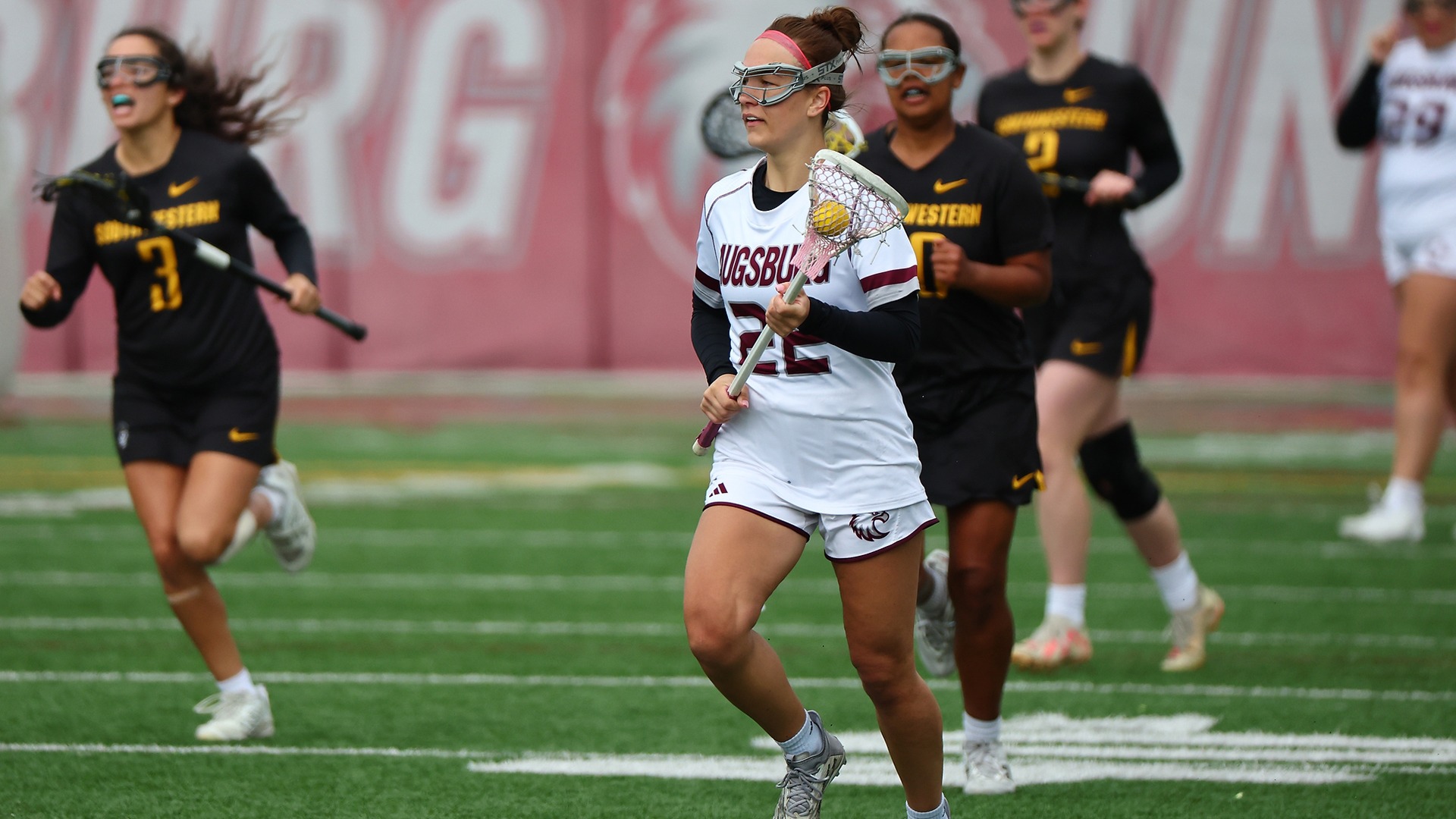 Leila Klym brings the ball up the field during a 2025 Augsburg women's lacrosse game.