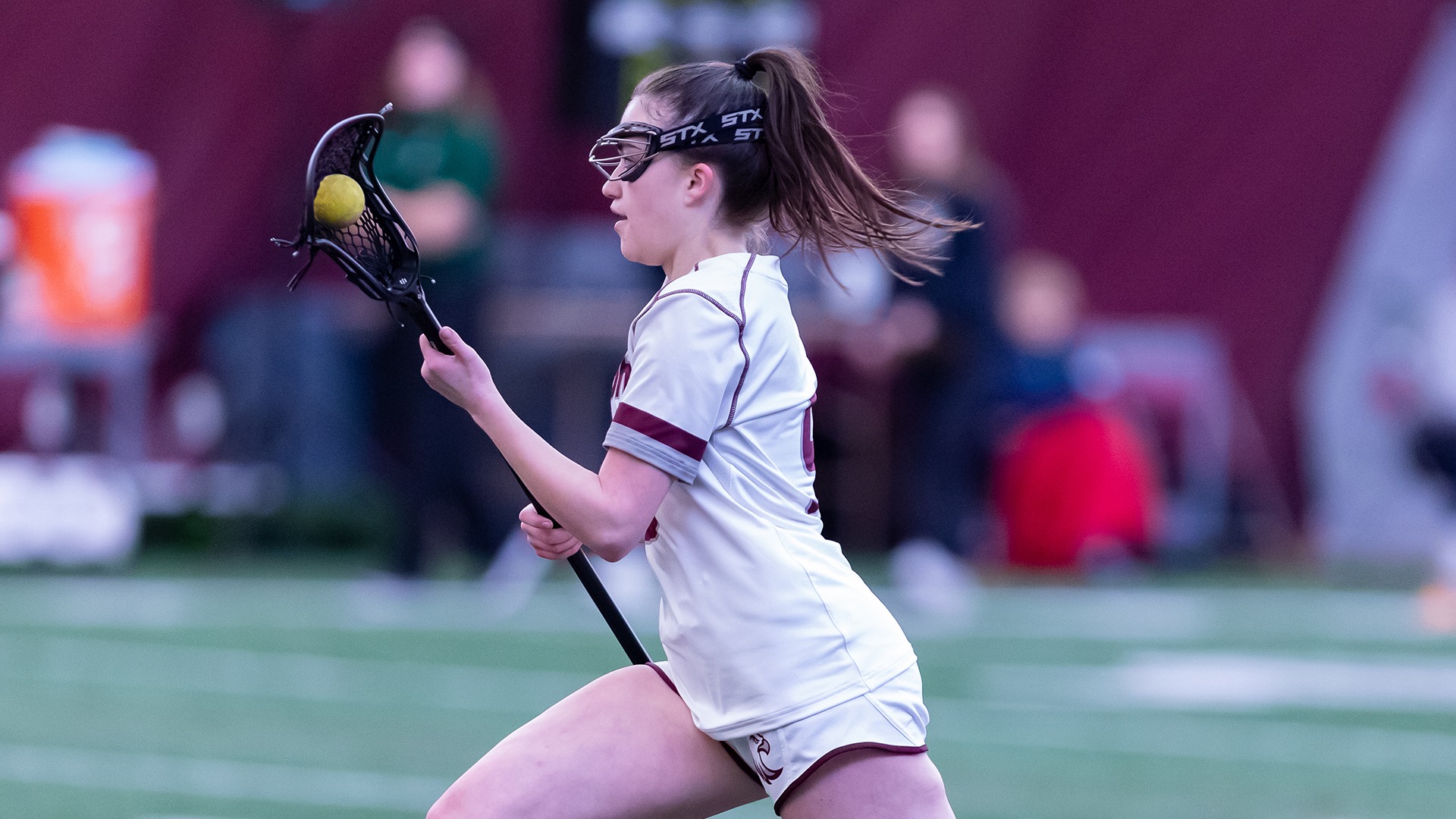 Isabella Kohout runs with the ball during a 2025 Augsburg women's lacrosse game.