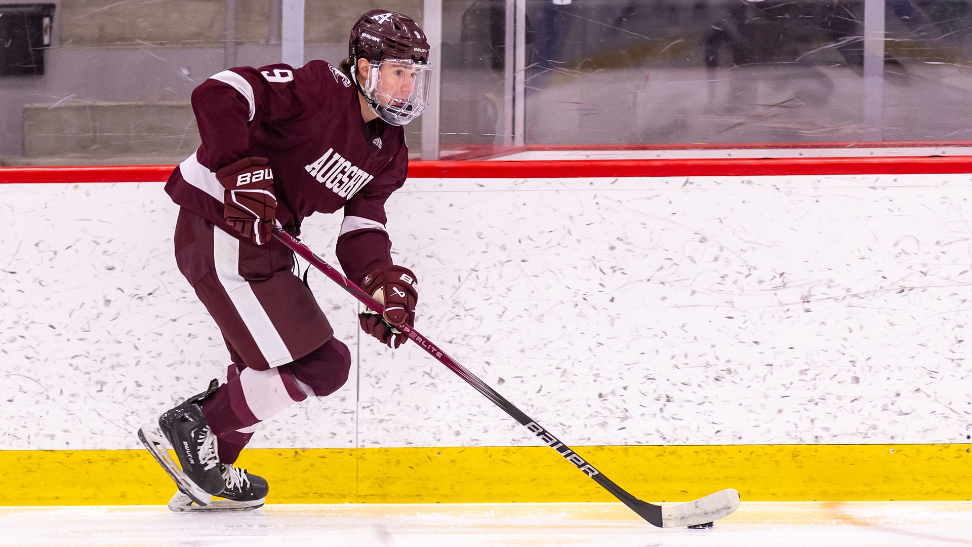 Landon Parker brings the puck up the ice during a 2024-25 Augsburg men's hockey game.