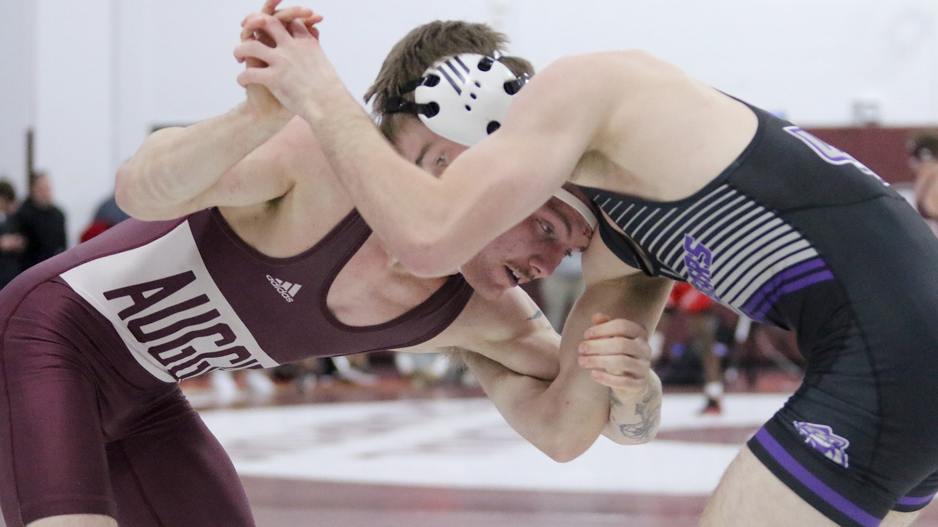 Karsen Otis attacks underneath an opponent during a 2025-26 Augsburg men's wrestling meet.