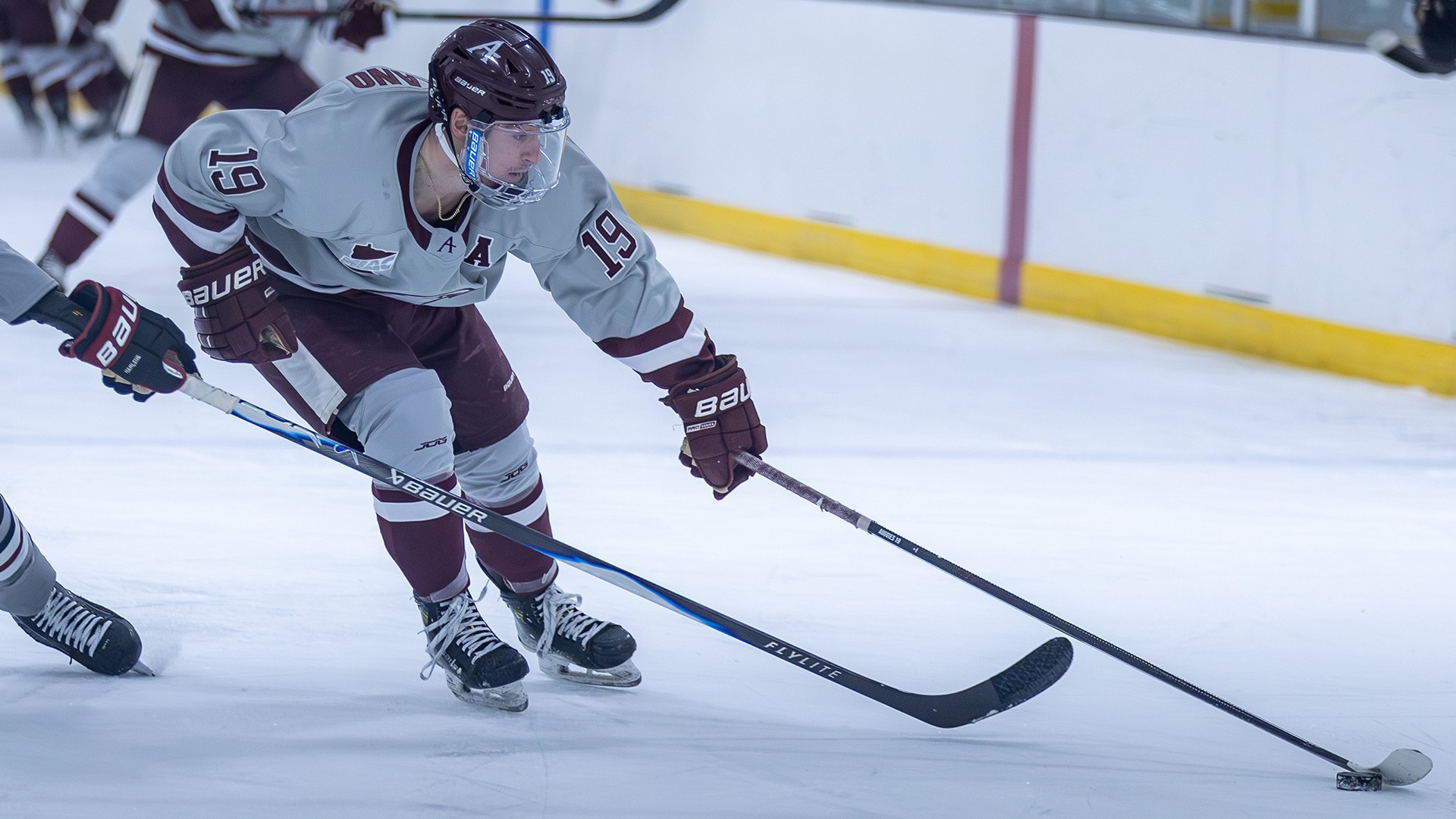Nick Catalano reaches for the puck during a 2025-26 Augsburg men's hockey game.