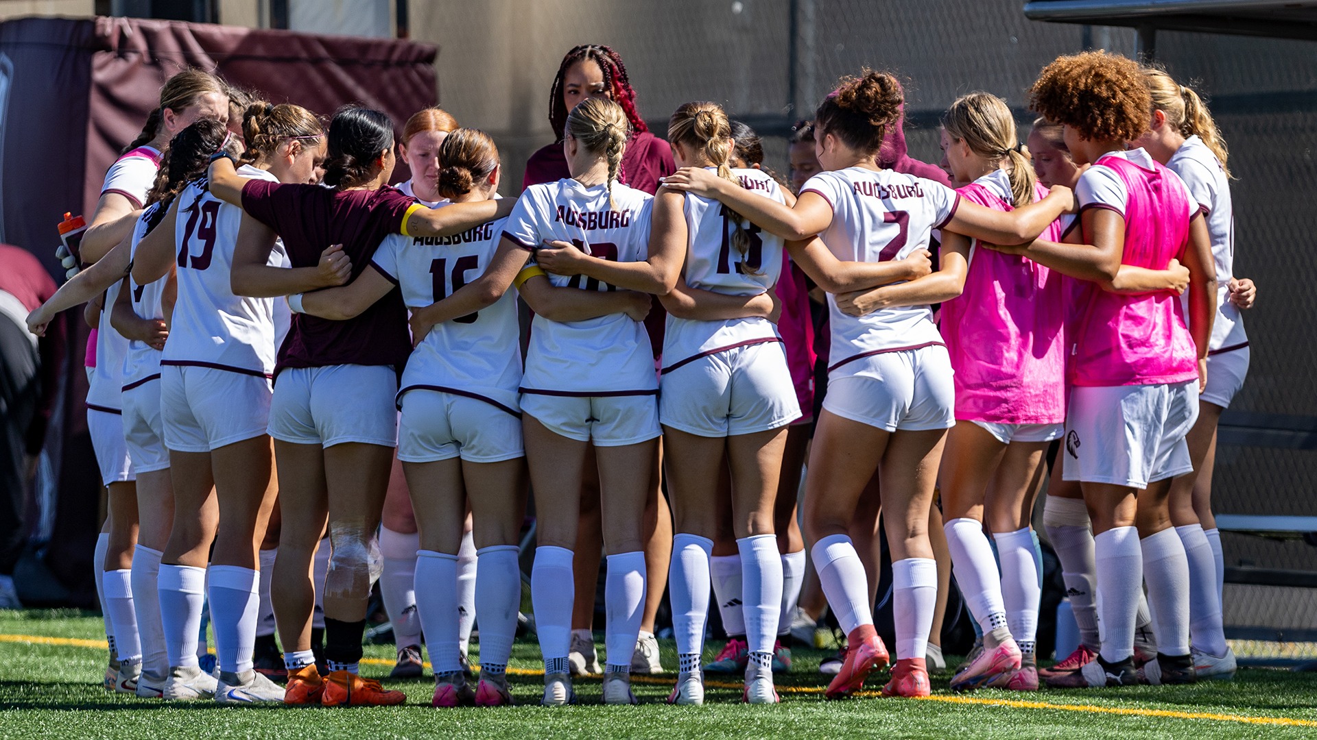Augsburg women's soccer team members gather in a huddle before a 2026 game.