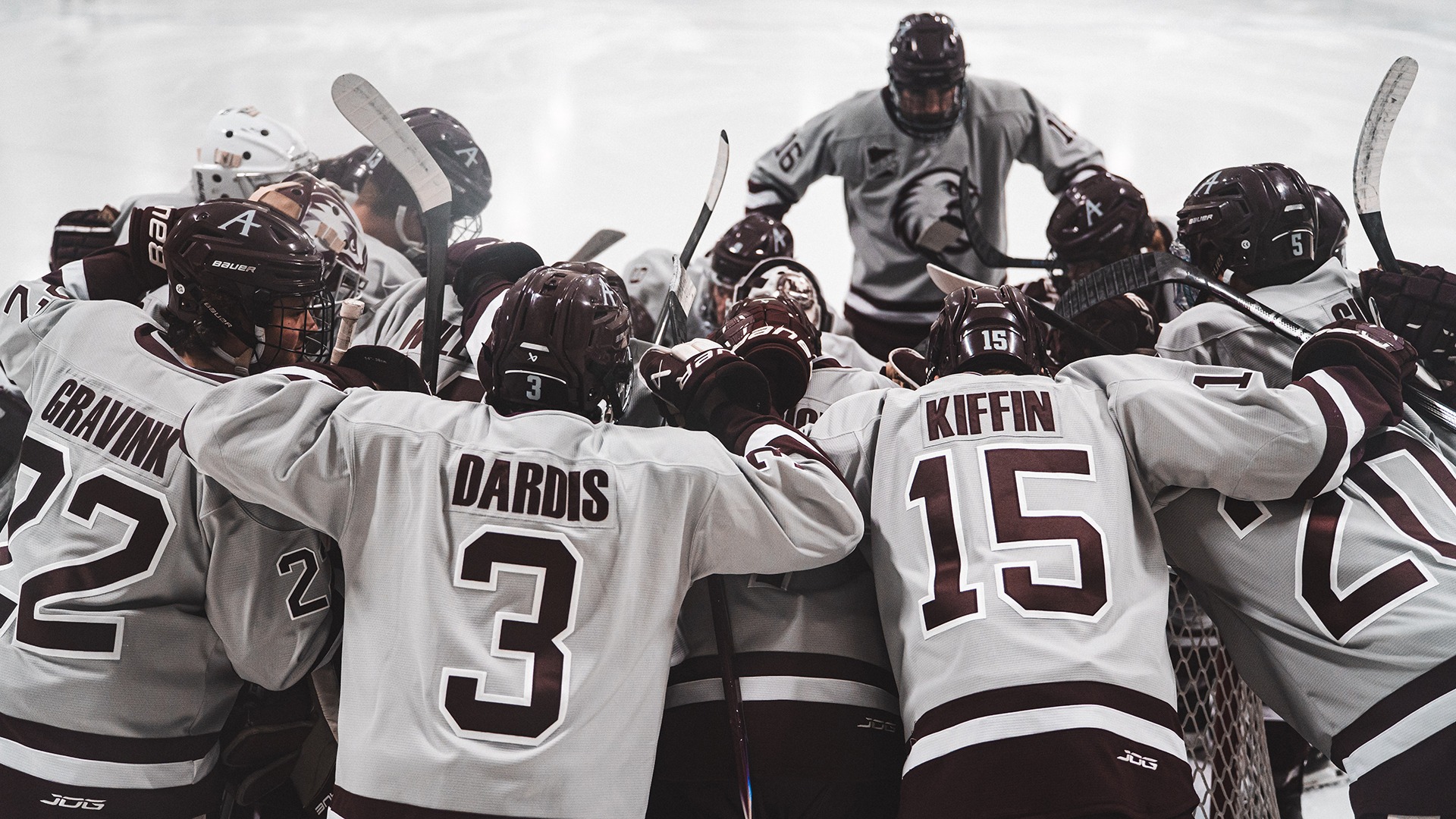 Augsburg men's hockey players huddle before a 2025-26 game.