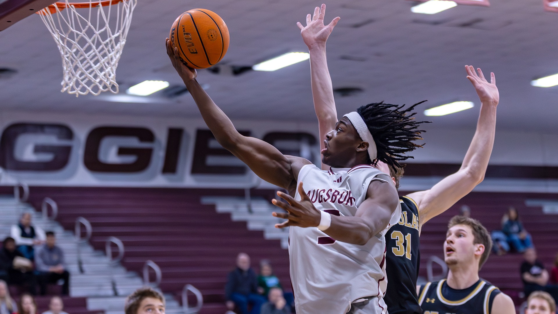 Elias Batala drives for a layup during a 2025-26 Augsburg men's basketball game.