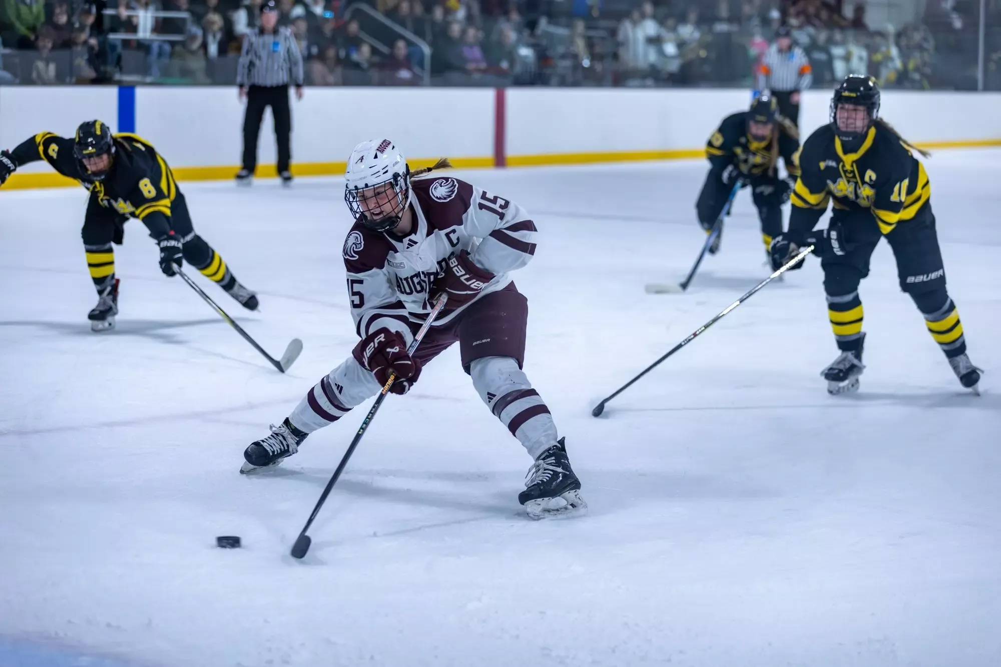 Tenley Stewart handles the puck during a 2025-26 Augsburg women's hockey game.