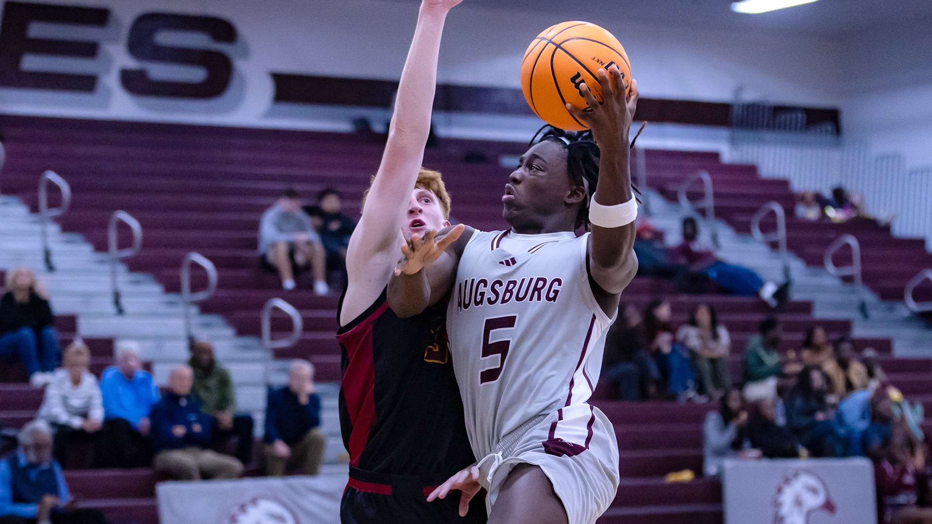 Elias Batala drives for a layup during a 2025-26 Augsburg men's basketball game.