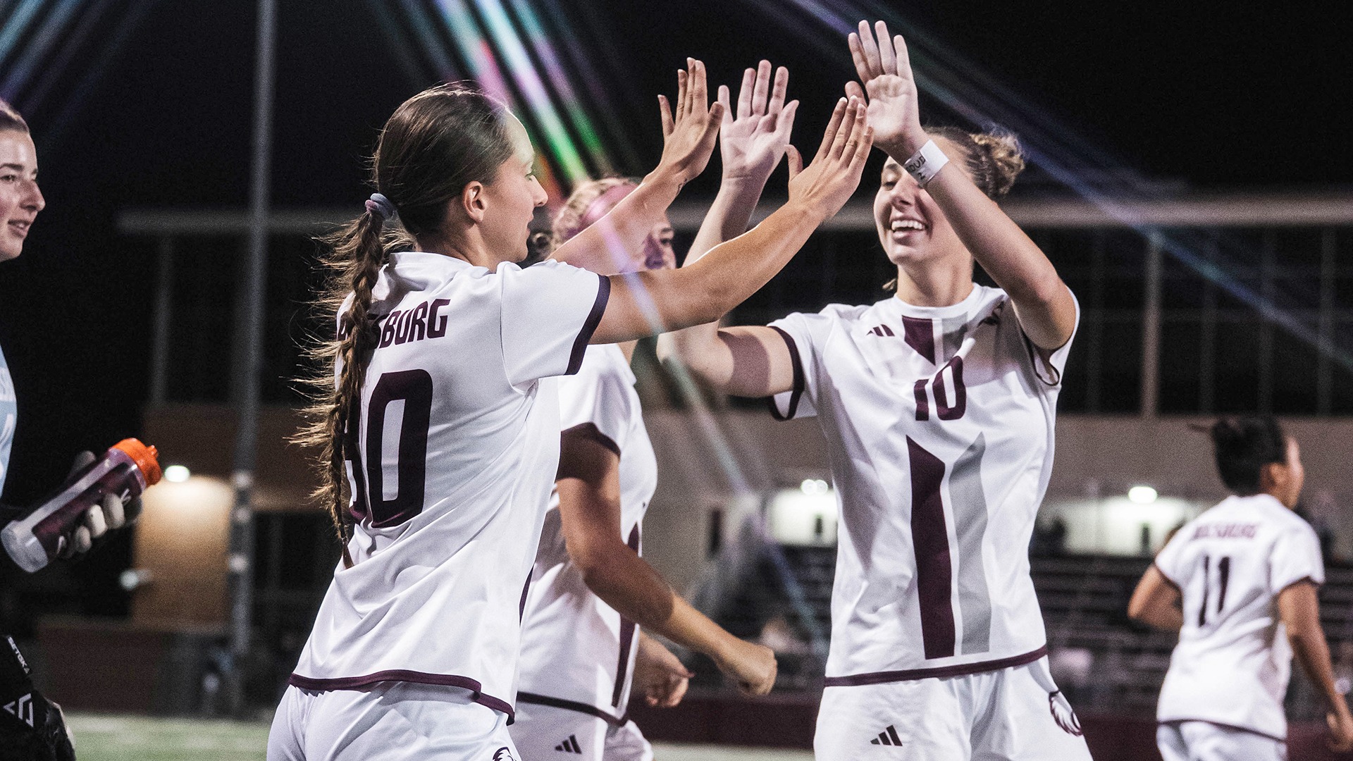 Augsburg women's soccer players give a high five during a 2025 game.