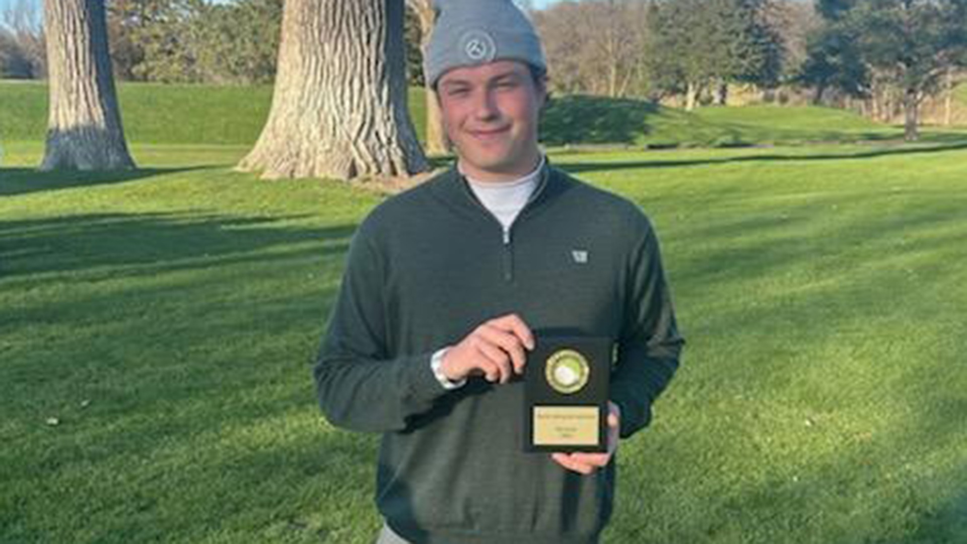 Jack Berry displays his trophy after winning a 2025-26 Augsburg men's golf meet.