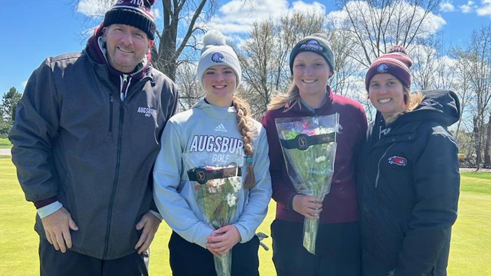 Augsburg women's golf seniors Marissa Paaske and Hannah Larson pose with coaches Eric Rolland and Avery Sawchuk after a 2025-26 meet.