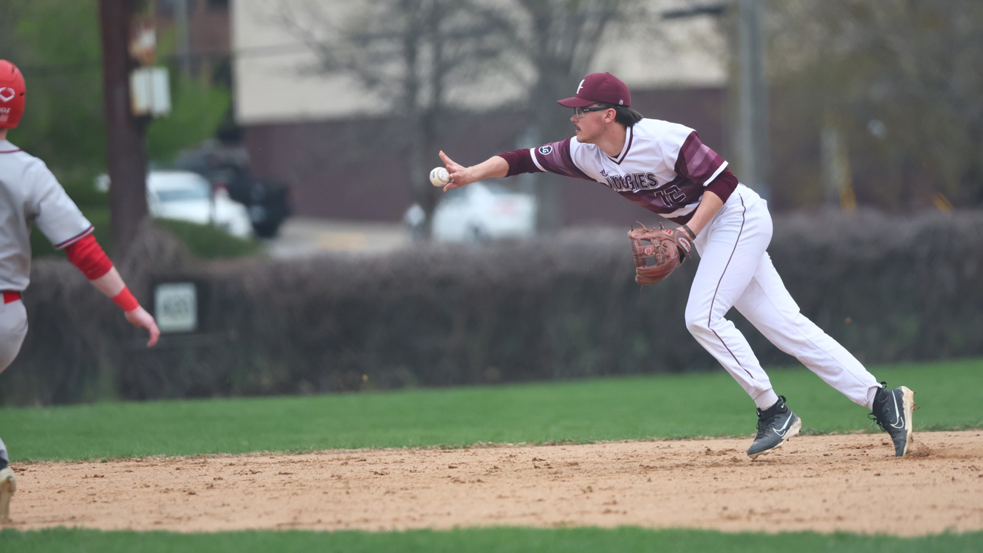 Drew Jenkins throws the ball toward second base during a 2026 Augsburg baseball game.
