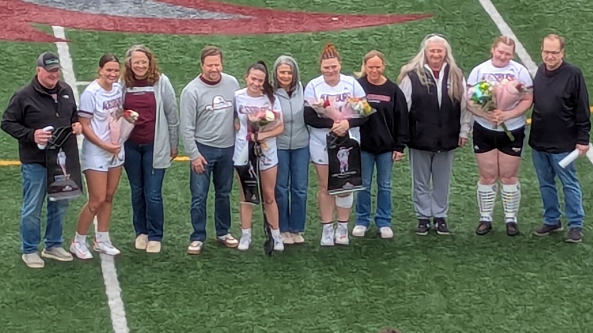Augsburg women's lacrosse seniors and their families pose for a photo.