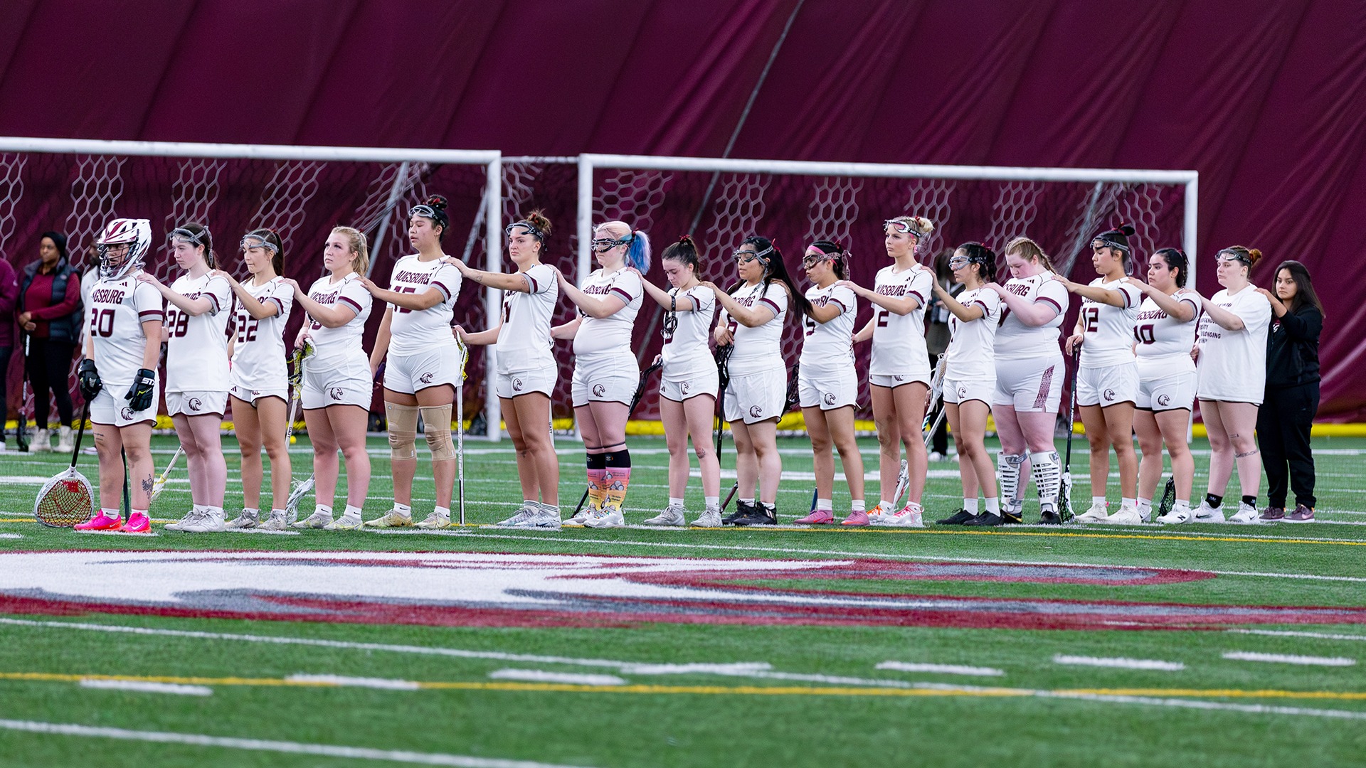 Augsburg women's lacrosse players line up for the National Anthem prior to a 2026 game.