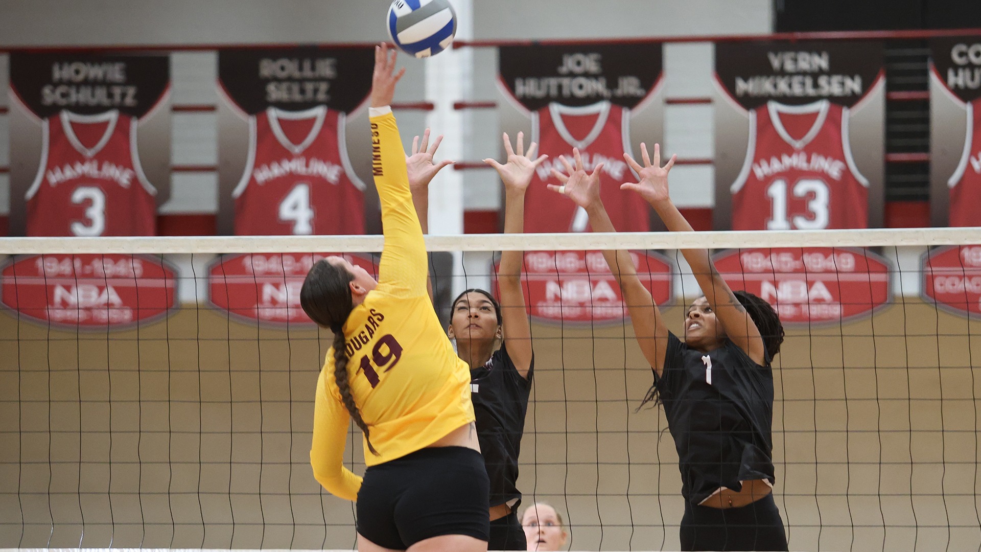 Lilly Wynn and Ameerah Rogers go up for a block during a 2026 Augsburg volleyball match.