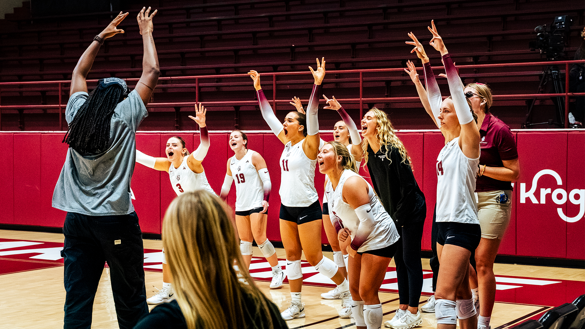 Volleyball bench celebrates an ace with assistant coach Aiko Jones
