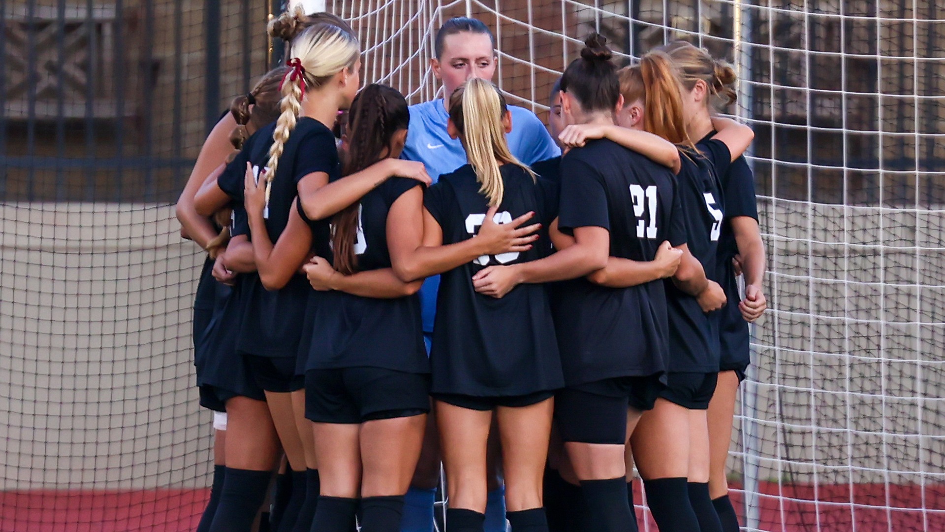 Women's soccer huddles before a game this season.