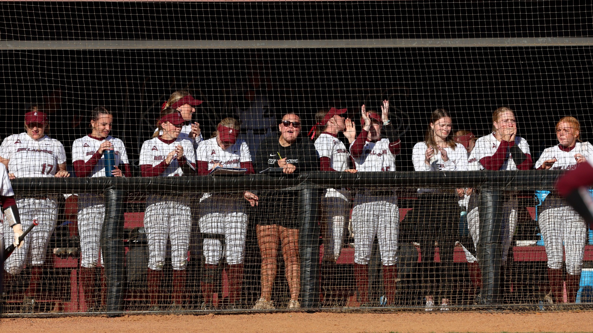 Softball team cheering in the dugout