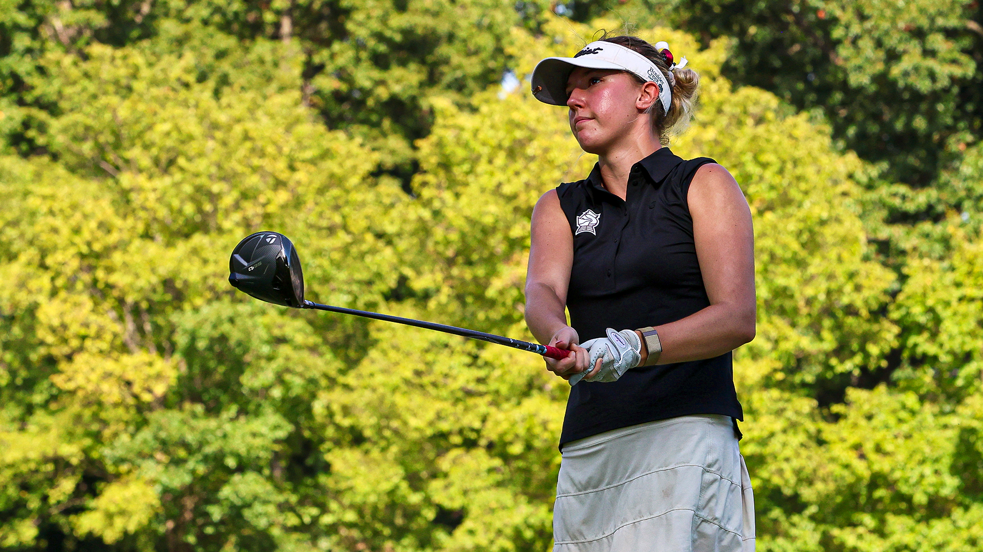 Rozlyn Rooke watches the ball on the tee box after a drive 
