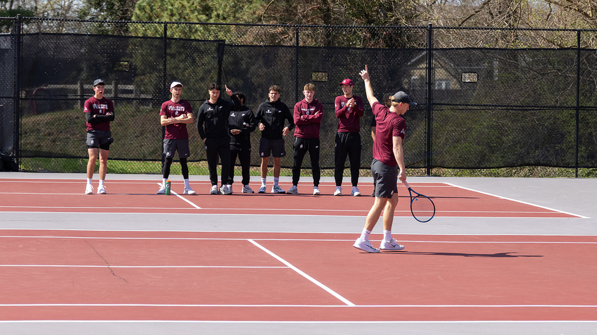 Eli Wood signals out with his teammates watching on the side