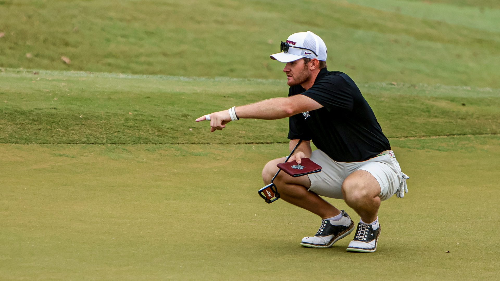 Ben Davenport points out the break as he reads the green before a putt