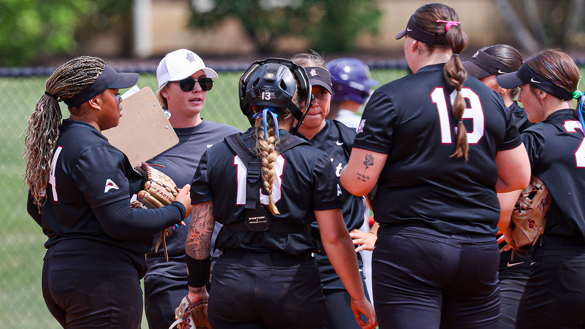 Head coach Whitney Arion talks with her infield during a game