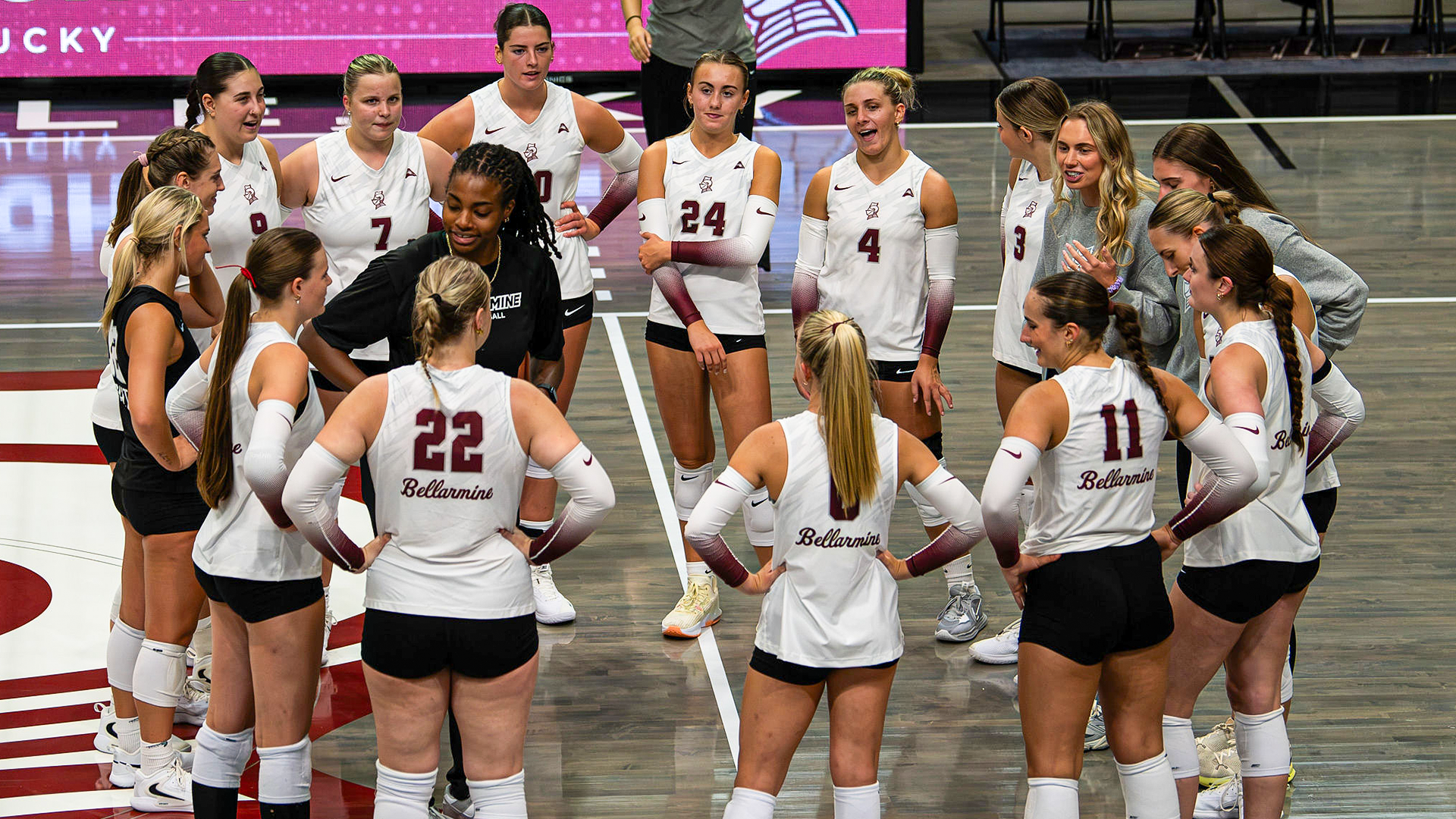 Volleyball team circled up before their exhibition match against WKU