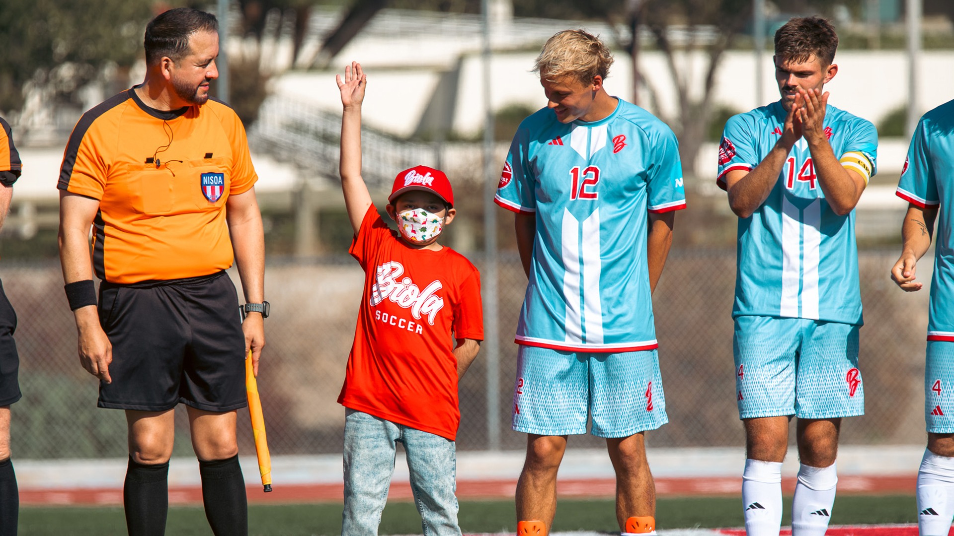 Matthew waving from on pitch